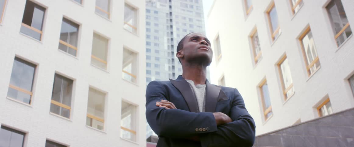 A man is standing outdoors in a city