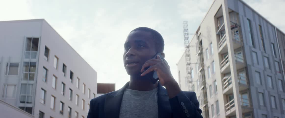 A man is talking on a cellphone in a downtown city