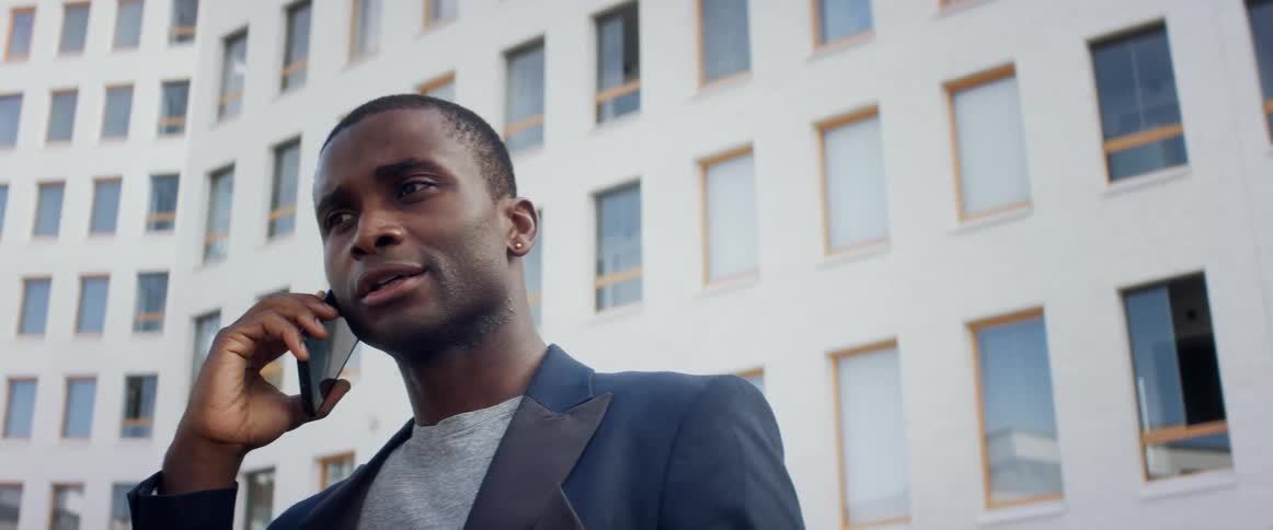 A man is talking on a cellphone in an urban city