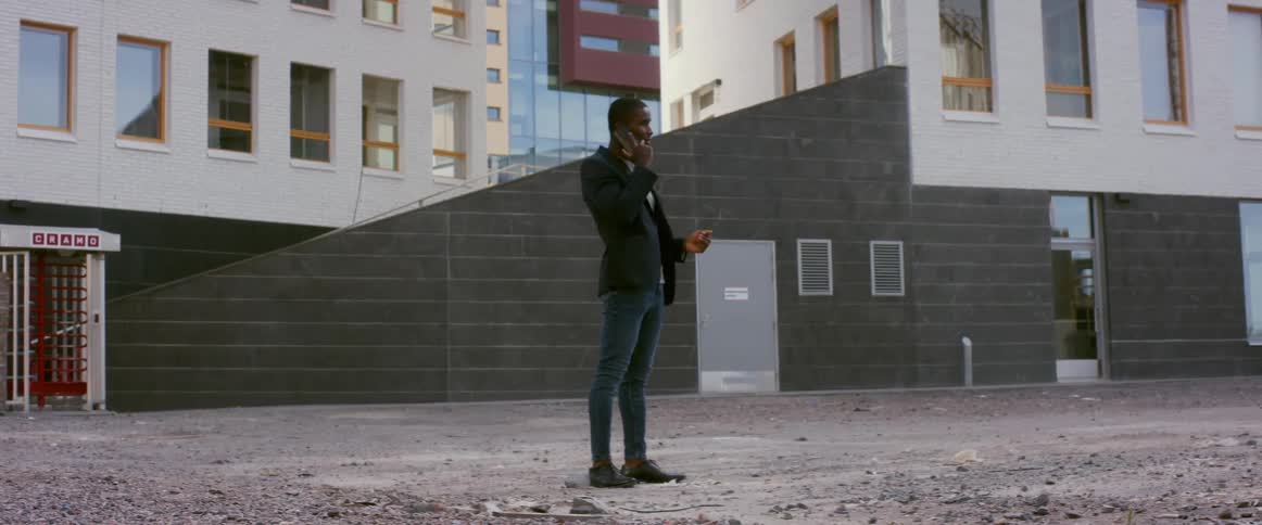 A man is talking on his cellphone outdoors in a city