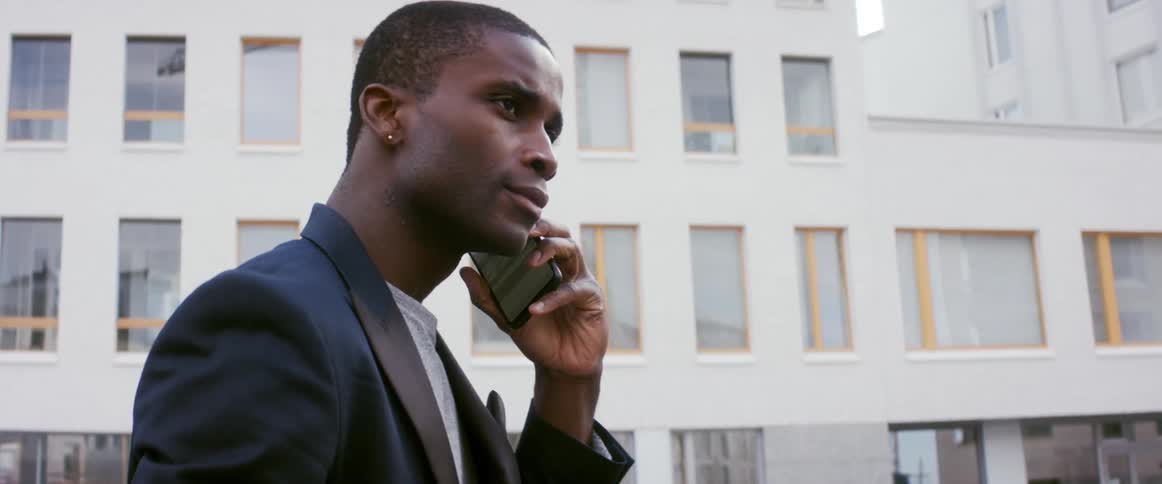 A man is talking on his cellphone in a downtown city