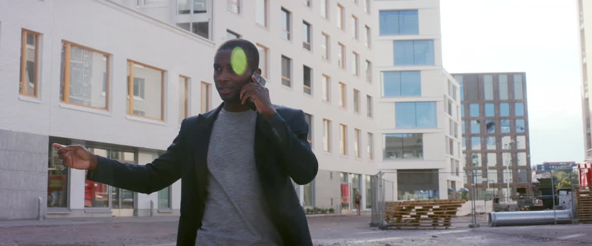 A man is talking on his cell phone in an urban city