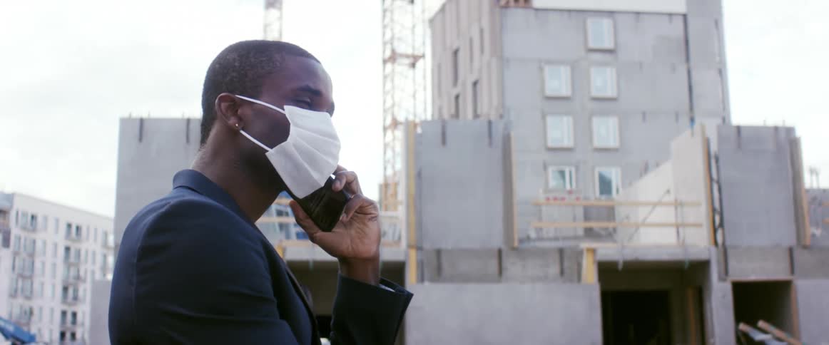 A man talks on the phone at a construction site