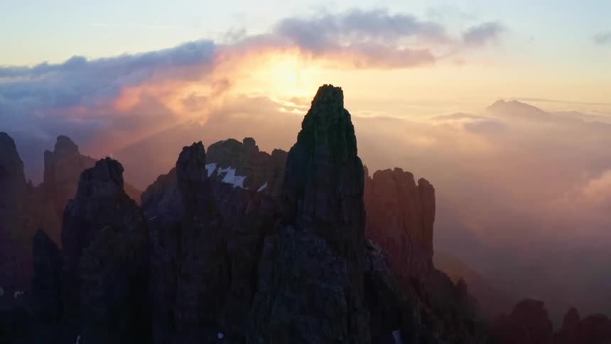 Aerial view of tall promontories in the peak of a mountain range at sunset