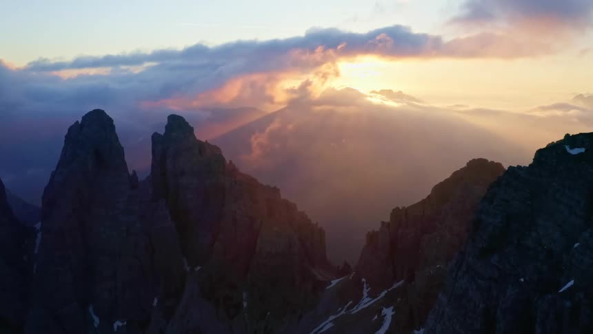 The sun is setting in the horizon above the mountains