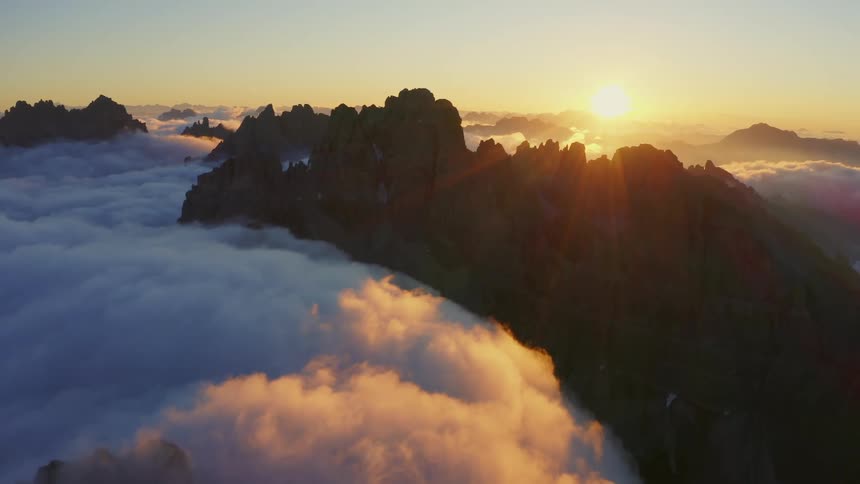 The sun is rising on the tall mountains
