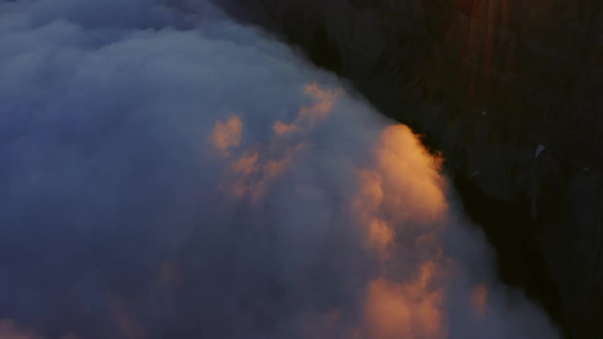 Aerial view of the clouds and sun over a mountain range