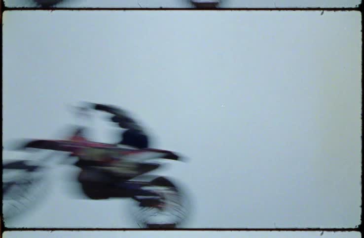 Person rides motorcycle under clear blue sky