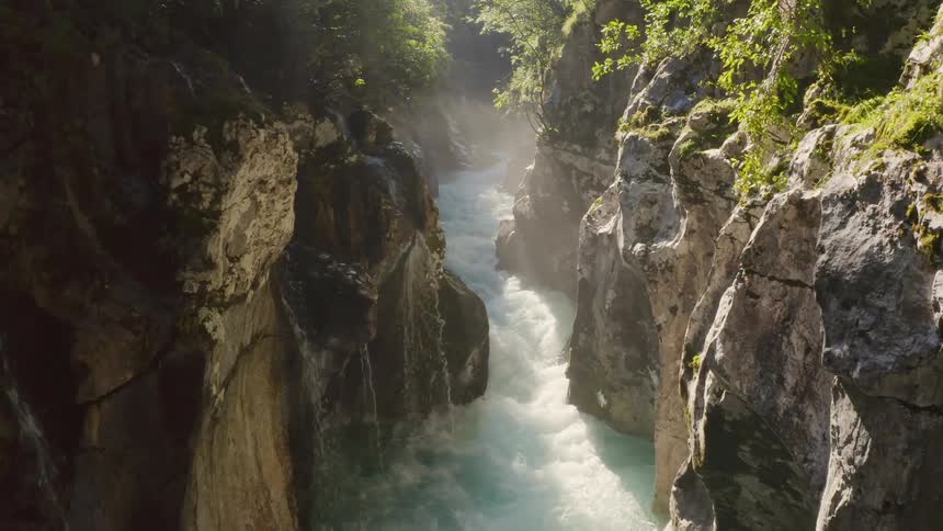 Small waterfalls flow off the side of a canyon and onto a narrow river