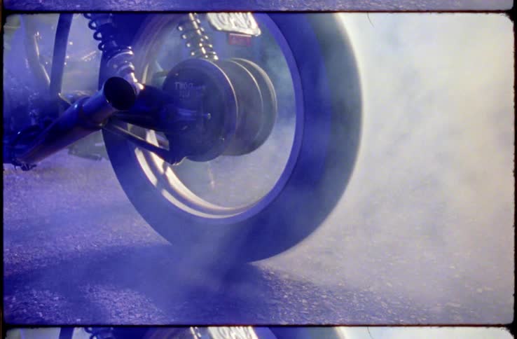 A motorcycle wheel spinning with smoke