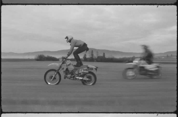 2 people on there motorbikes on empty land