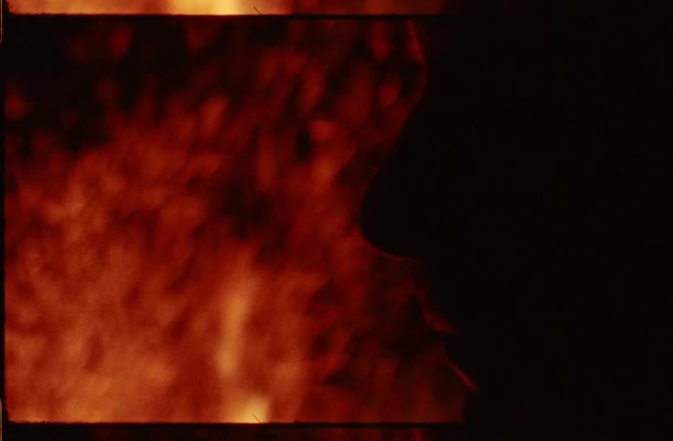 A man and woman talking in front of a bonfire