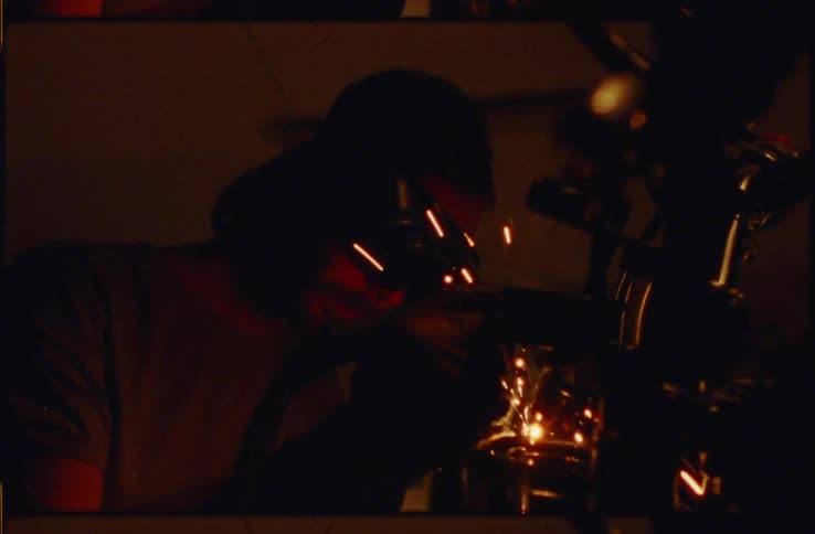 A man with goggles welding with sparks