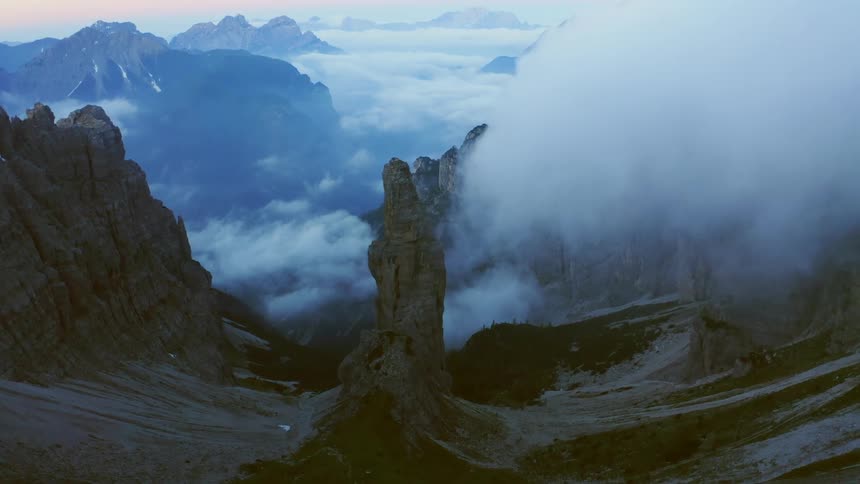 Dense clouds and fog obscure the peaks of a mountain range