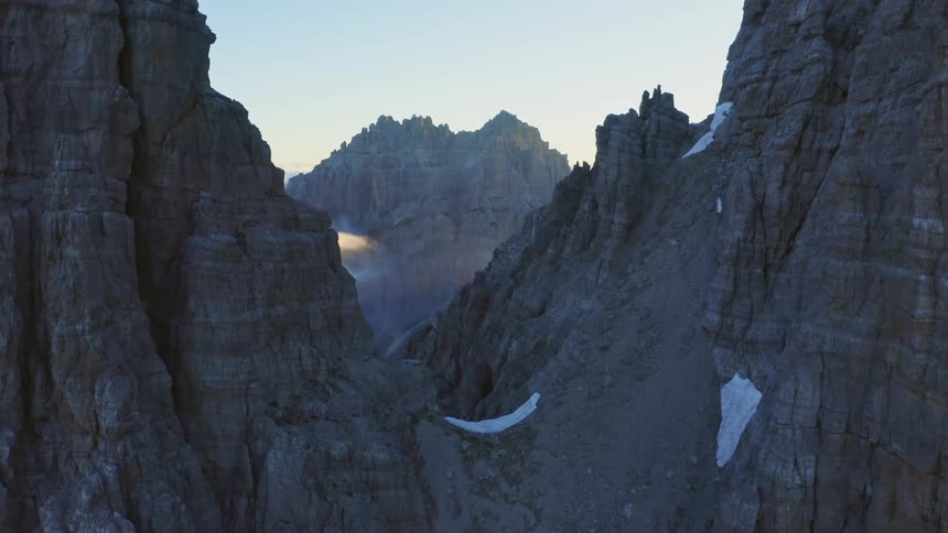 An aerial view of rocky mountain peaks with snow in nature