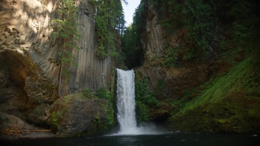 Water falls from a ravine covered in vegetation