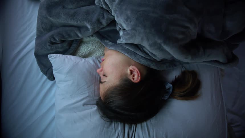 A woman is sleeping on a bed
