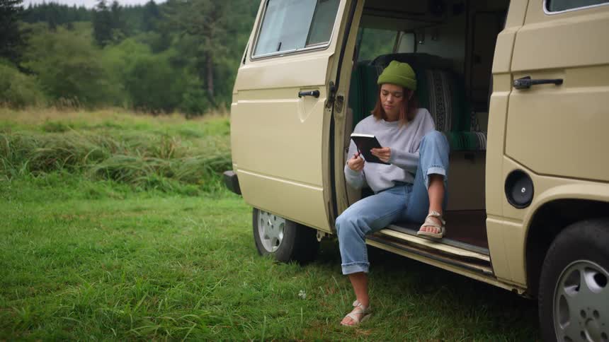 A woman is sitting in her van