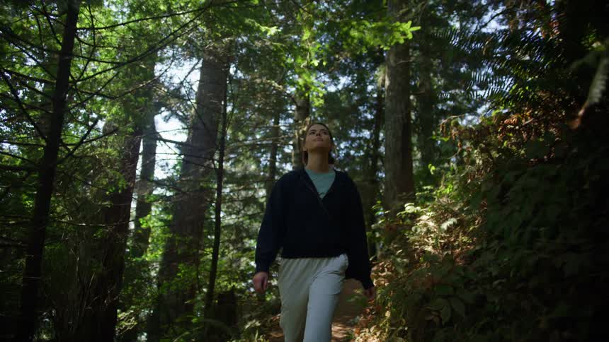 A woman is hiking through the woods