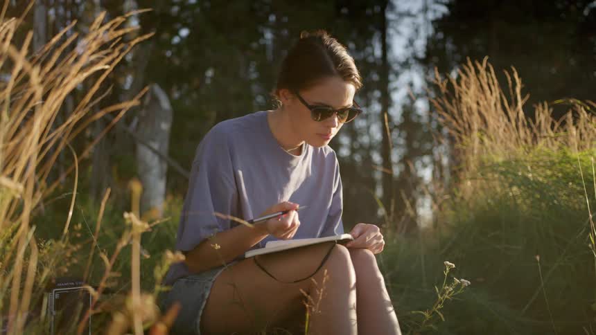 A woman is writing in a journal in spring
