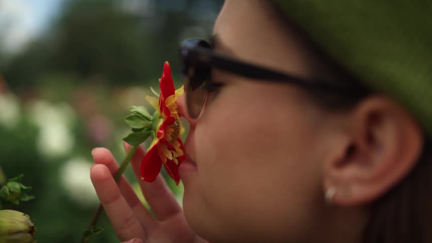 A woman is smelling flowers outside in spring