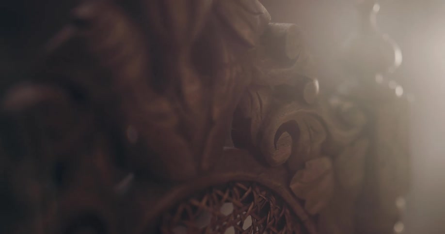 Light shining on an ornately carved wood chair