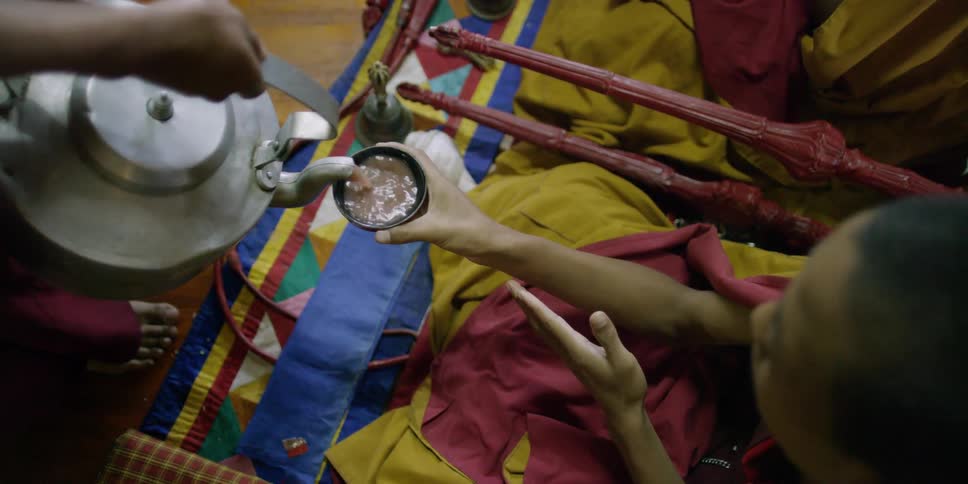 Tea is poured into a buddhist monk's cup