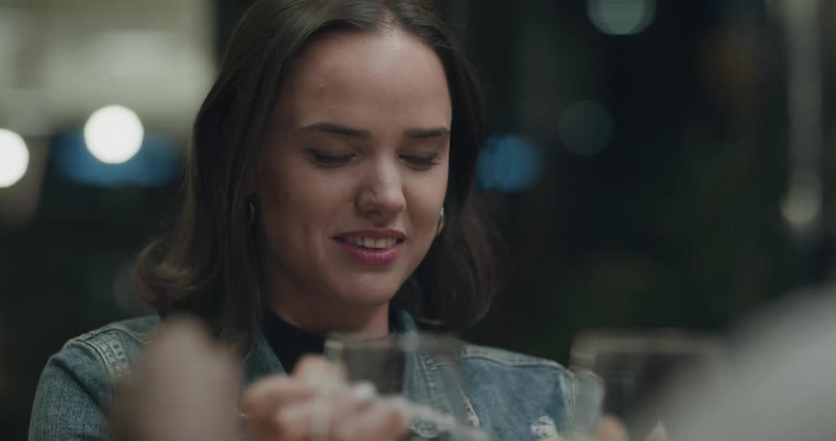A woman eating in a restaurant laughs and talks with others