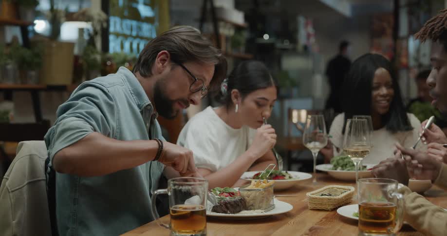 Friends are eating drinking and talking in a restaurant
