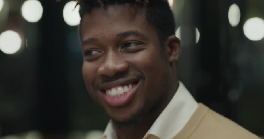 Man talks and laughs over a meal in a restaurant with friends at night