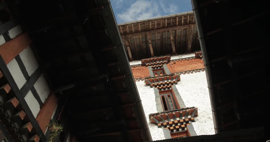 The upper stories of an old building seen from a semi-open lower courtyard