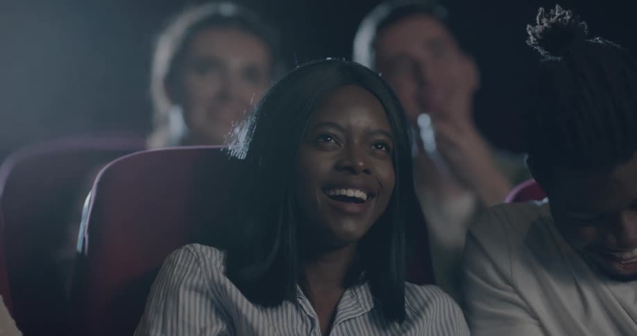 People sitting at a movie theater laughing