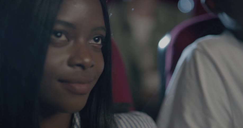 A black male and female sitting together in a theater talking