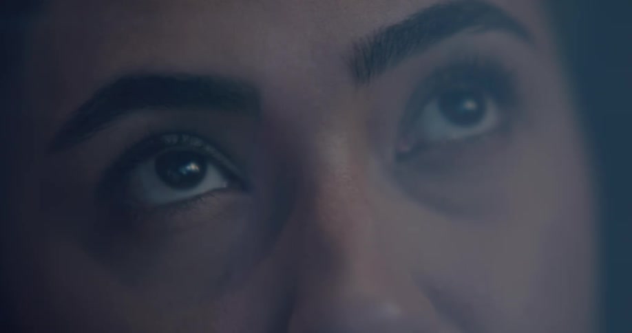 Light reflects in womans eyes as she looks upward