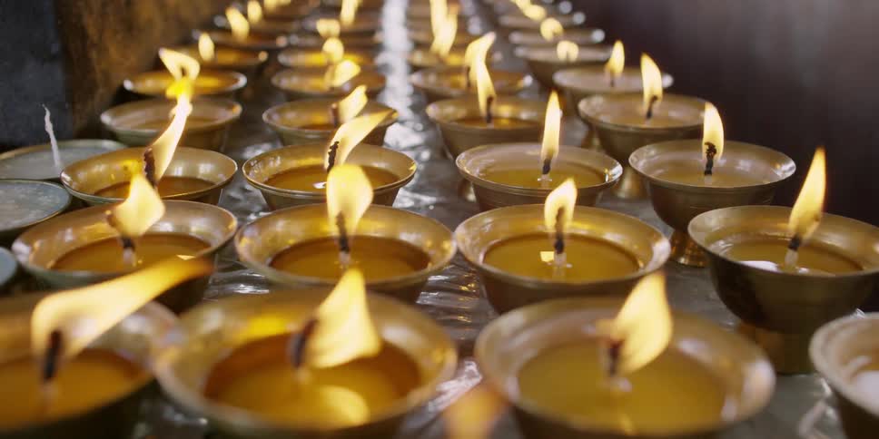 Four rows of lit candles