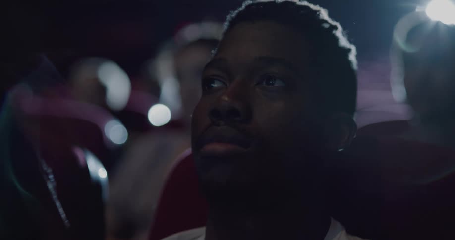 A young man watches a movie in a cinema theater