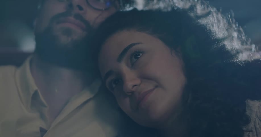 Woman leans on man and he kisses her hair