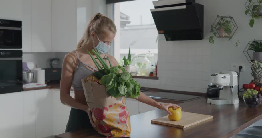 A woman unpacks groceries in her kitchen