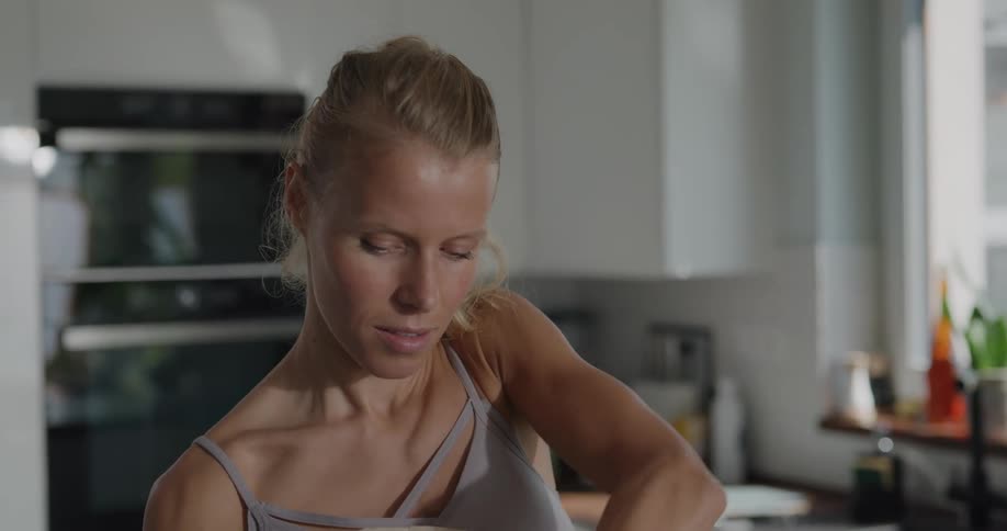 A woman in the kitchen taking fruit and vegetables out of a bag