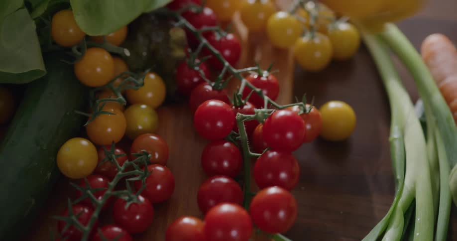 Woman takes some red and yellow tomatoes in the kitchen