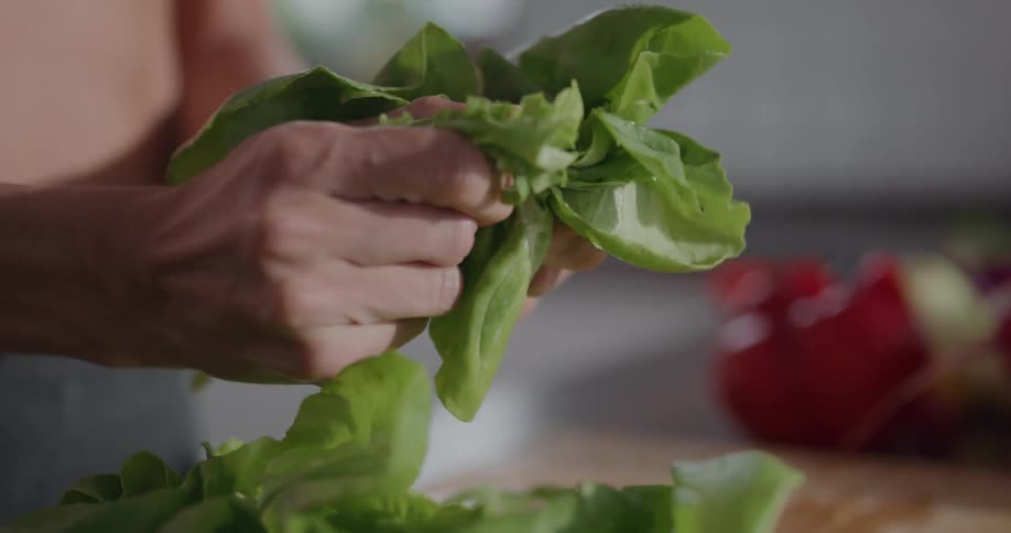 A woman at home ripping lettuce