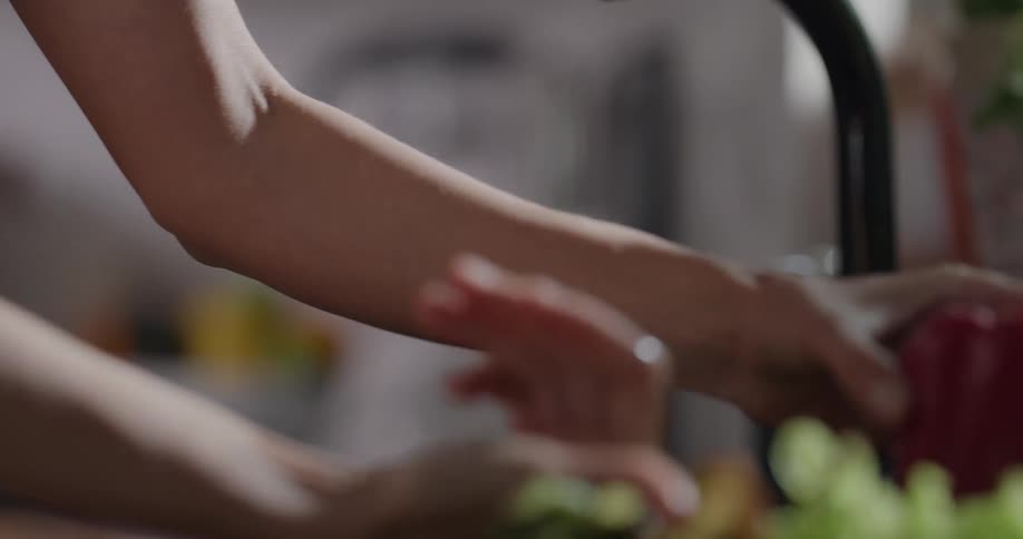 Woman turns on water to rinse produce