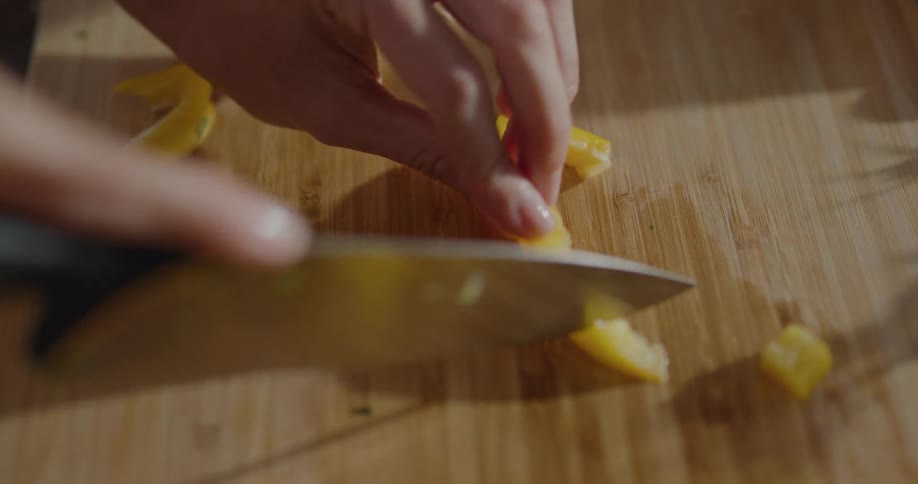 A woman cutting a bell pepper at home