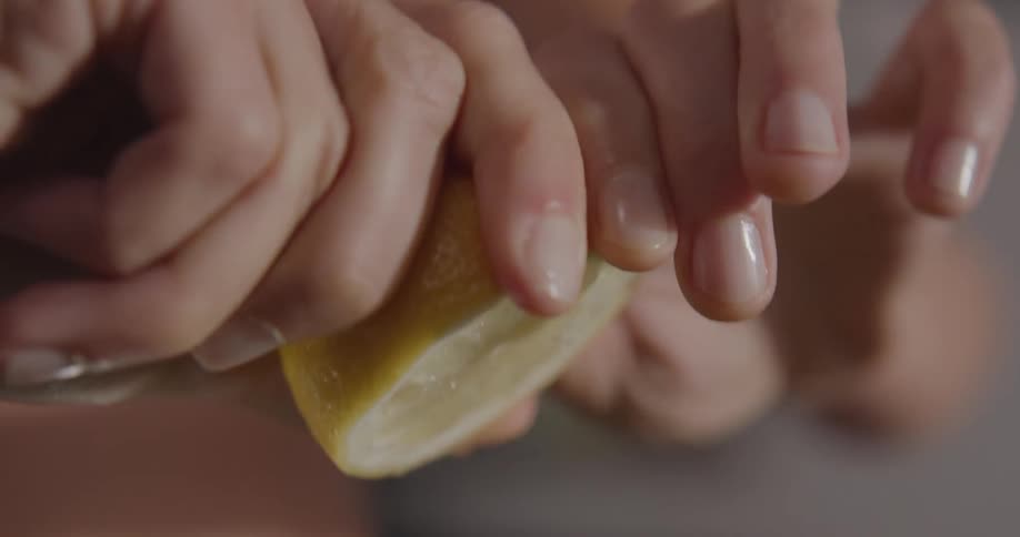 A woman cooking at home squeeze a lemon