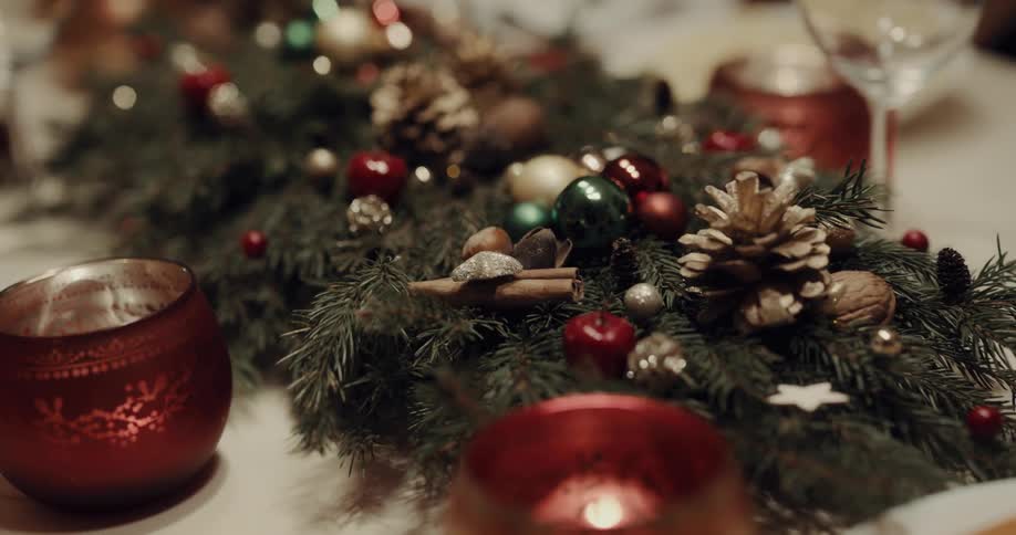 Christmas decor on a dining table with candles and wine glasses