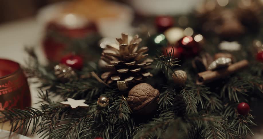 Fern with christmas decorations on it focusing on the acorn