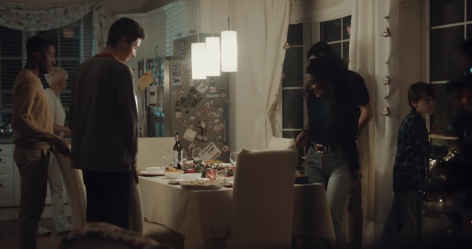 A woman and her son call people to the table and they all sit down