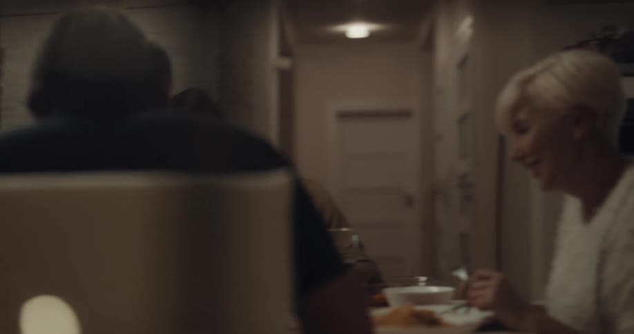 A family sitting at the table laughs and sings