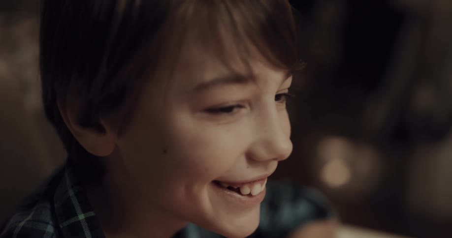 A young boy laughing at the dinner table