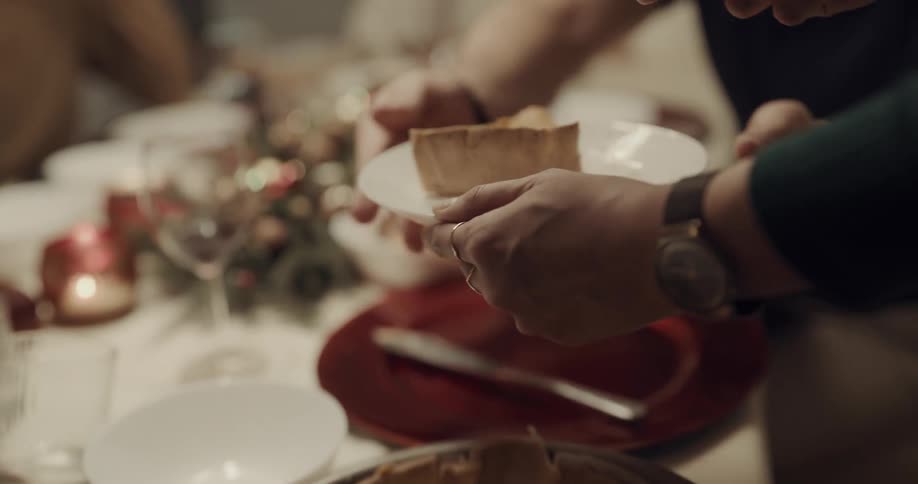 A man serves up pie to a family member at a holiday dinner